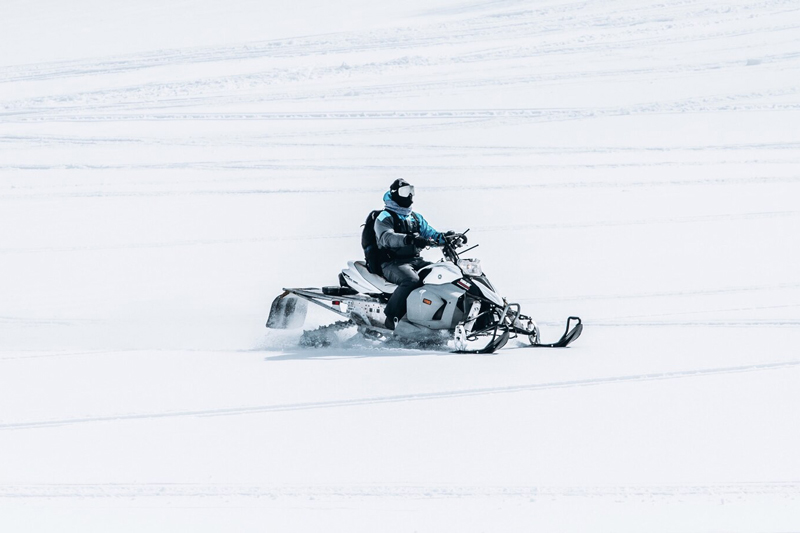 male-riding-snowmobile-large-snowy-field_181624-1940d51